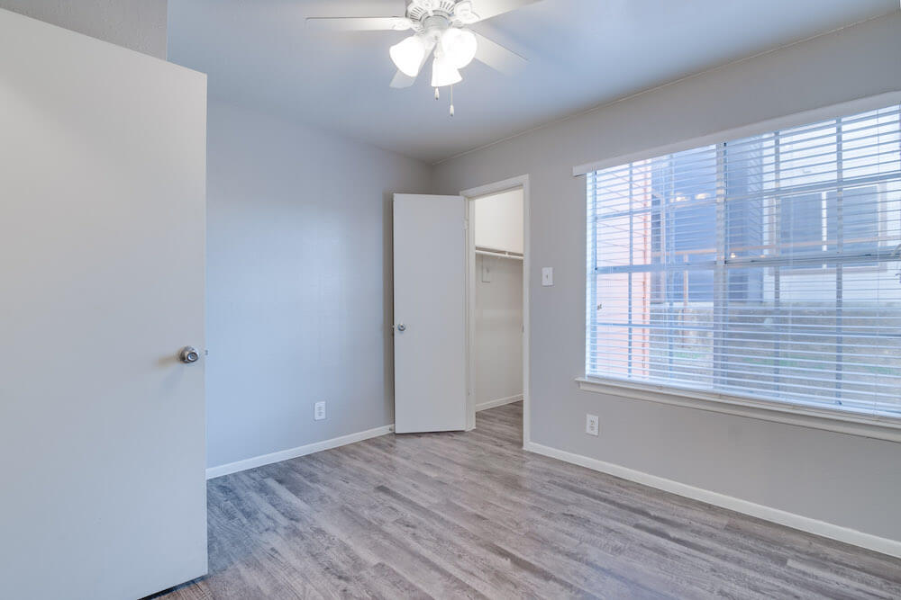 Bedroom with large window and ceiling fan.